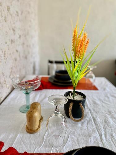 a table with a white table cloth with a vase and a plant at Kiamboni in Nakuru