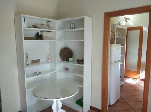 een witte kamer met een tafel en een koelkast bij Casa de Andrães Magnolias in Marco de Canavezes