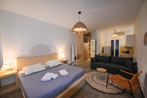 ein Schlafzimmer mit einem blauen Bett und einem Sofa in der Unterkunft Fabio Studios in Kionia