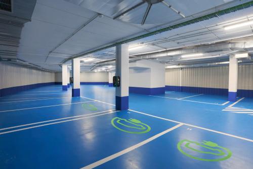 an empty parking garage with blue floors and white columns at Hotel MyPalace León in León