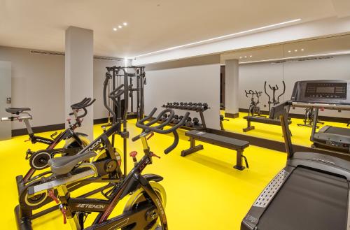 a gym with several treadmills and cardio machines at Hotel MyPalace León in León