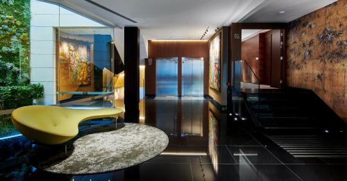 a lobby with a yellow chair and a staircase at Hotel MyPalace León in León