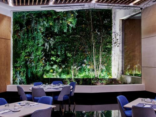 a restaurant with tables and chairs in front of a large window at Hotel MyPalace León in León