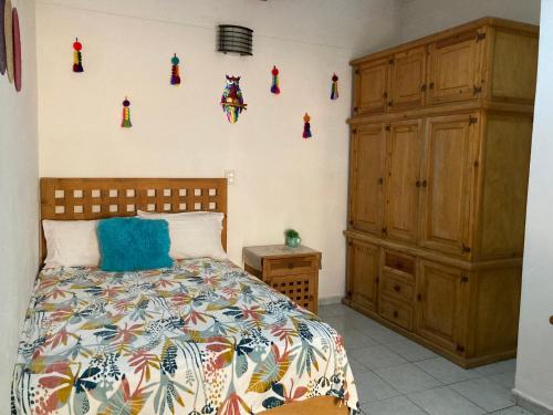 a bedroom with a bed and some decorations on the wall at Cómoda y amplia Habitación en Jalatlaco in Oaxaca City