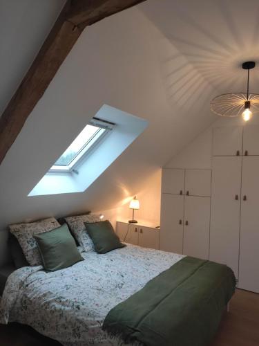 une chambre avec un lit dans un grenier dans l'établissement La Poulinière, à Méneslies