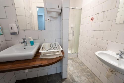 a white bathroom with a sink and a mirror at Trzy Kafki Private Rooms in Kraków
