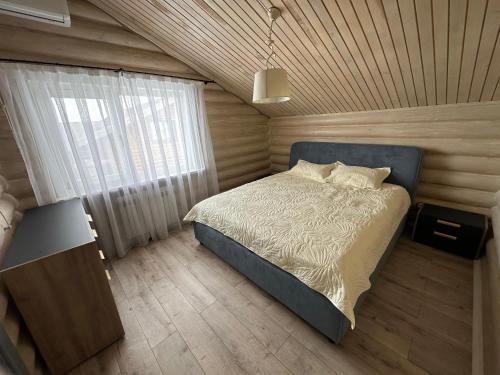 a bedroom with a bed with a wooden ceiling at Бозайгыр in Kuprinka