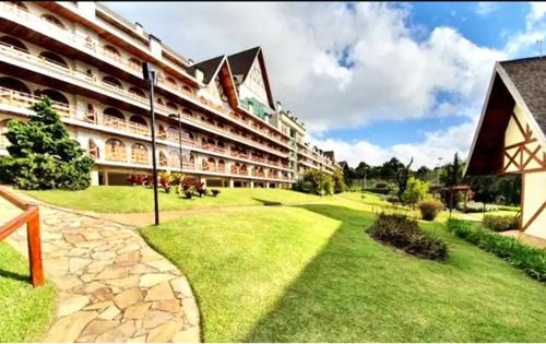 a large building with a green lawn in front of it at Apto luxuoso!!! Alto Capivari, Campos do Jordão. in Campos do Jordão