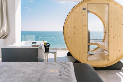 a bedroom with a wooden circular room with a view of the ocean at Akrotiri Olympus Luxury Suites - Adults Only in Plaka Litochorou