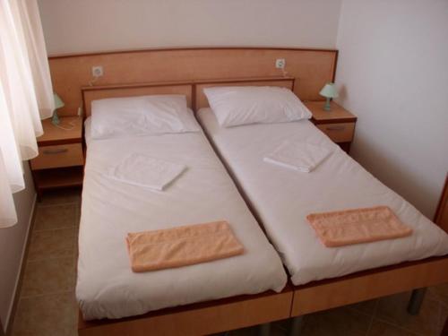 a bed with two pillows on it in a room at Villa Maja original since 2005 in Baška Voda