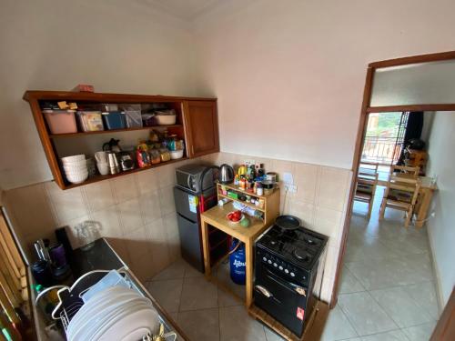 a small kitchen with a stove and a refrigerator at Bukoto Private Room in Kampala