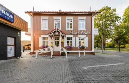 a large brick building with a clock on the front of it at Vila Arnika in Druskininkai