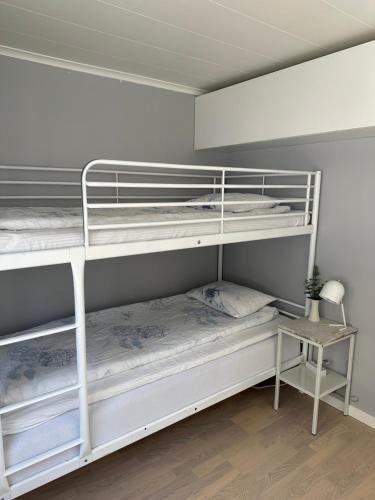 a bedroom with two bunk beds and a table at Stuga med havsutsikt in Robertsfors