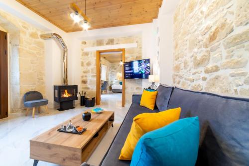 a living room with a blue couch and a stone wall at Asmani in Kato Asites