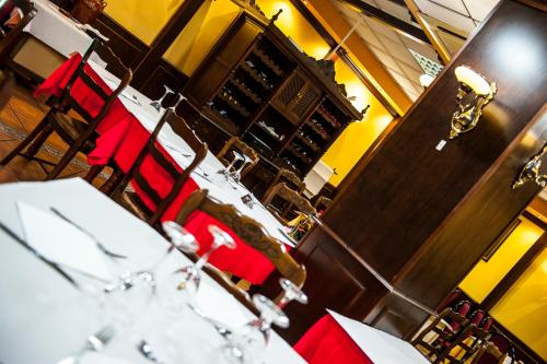 a restaurant with red chairs and tables with wine glasses at HOSTAL LAS PALOMAS in Lucena