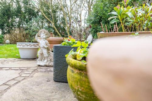 a garden with a statue and some plants at Haus-Archsum in Archsum