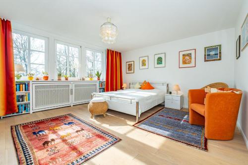 a bedroom with a bed and an orange chair at Haus-Archsum in Archsum