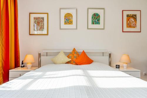 a bedroom with a white bed with orange pillows at Haus-Archsum in Archsum
