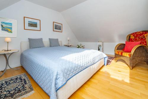 a bedroom with a large bed and two chairs at Haus-Archsum in Archsum