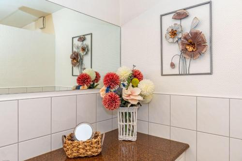 a vase of flowers on a table in a bathroom at Haus-Archsum in Archsum