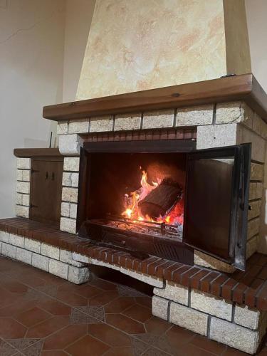 a large brick fireplace with a fire in it at casa rural Hachuelo in Montefrío