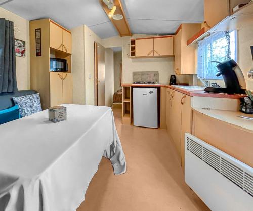 une cuisine avec une table et un chiffon de table blanc dans l'établissement Pause Dordogne Ambiance Cozy à Sarlat, à Sarlat-la-Canéda