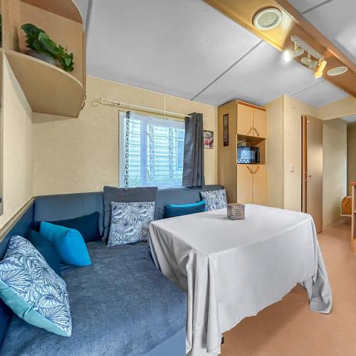 un salon avec un canapé bleu et une table dans l'établissement Pause Dordogne Ambiance Cozy à Sarlat, à Sarlat-la-Canéda