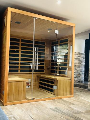 d'une grande armoire en bois avec des portes en verre. dans l'établissement Spa privatif à Bray-Dunes, à Bray-Dunes