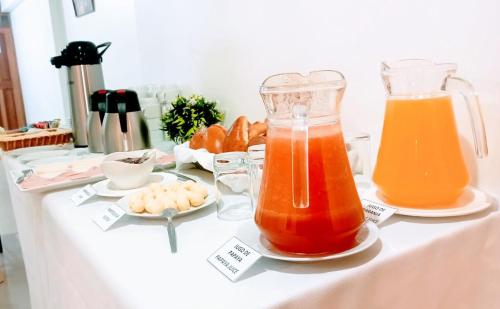 una mesa con dos jarras de zumo de naranja y aperitivos en Emmanuel inn Machupicchu, en Machu Picchu