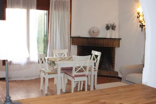 ein Esszimmer mit einem Tisch, Stühlen und einem Kamin in der Unterkunft La Gavina in L'Estartit