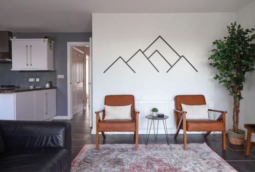 a living room with two chairs and a table at Modern 2 bed apartment at the Mournes in Newcastle