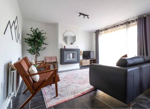 a living room with a couch and a chair at Modern 2 bed apartment at the Mournes in Newcastle