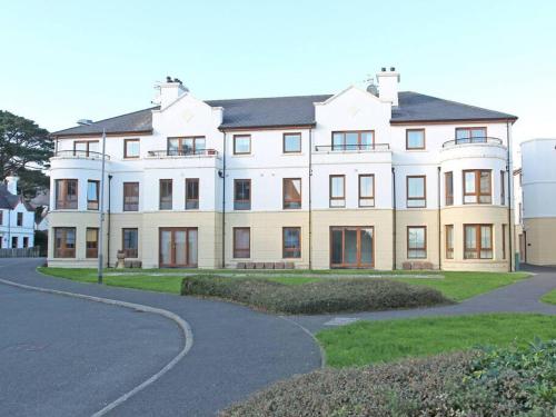 a large white house with a road in front of it at Modern 2 bed apartment at the Mournes in Newcastle
