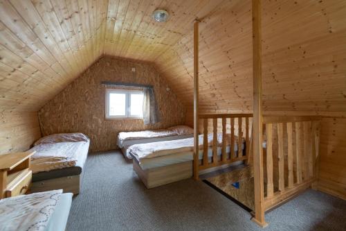 a room with two beds in a wooden cabin at Chaty Aqua Maria in Veľaty