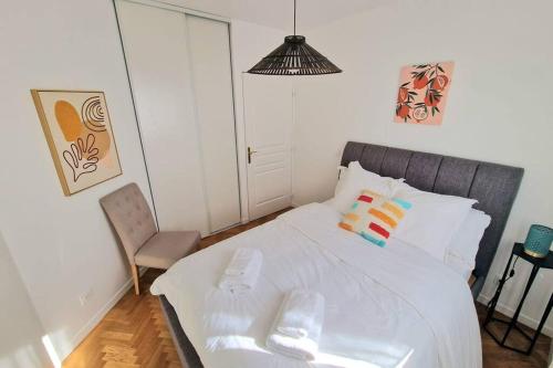 a bedroom with a white bed and a chair at Charme & Confort au Plessis in Le Plessis-Robinson