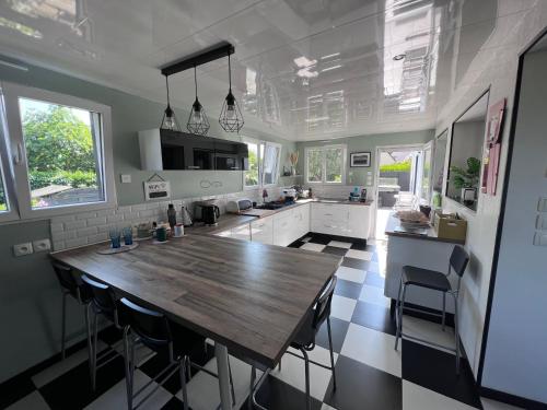 une grande cuisine avec une table et des chaises en bois dans l'établissement Bretagne, à Quéven