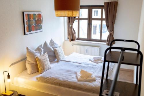 ein Schlafzimmer mit einem Bett mit Kissen und einem Fenster in der Unterkunft Ferienwohnung Schloss Kuckuckstein mit Infrarotsauna,WLAN, Hunde nach Absprache in Liebstadt