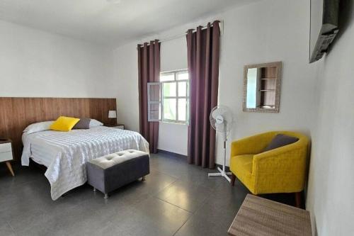 1 dormitorio con 1 cama y 1 silla amarilla en Casa en Playa Tortugas, Casma, en Tortuga