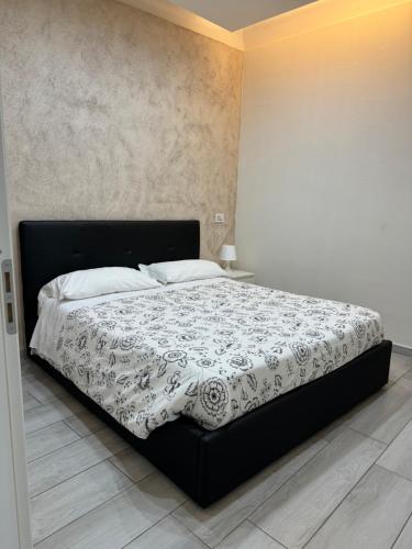 1 dormitorio con 1 cama con edredón blanco y negro en Meghan Home, en Catania
