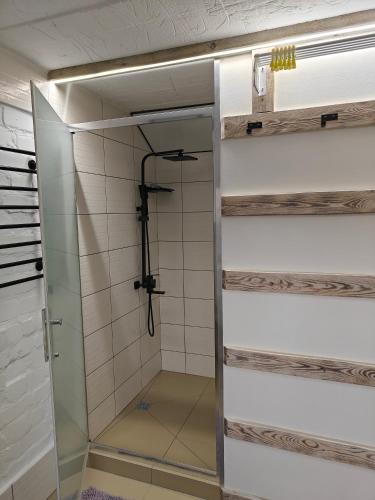 a shower with a glass door in a bathroom at loft apartments OLD MILL in Sarny