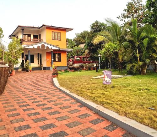 a house with a brick driveway in front of a yard at 7TH HEAVEN Kannur in Chakkarakkal