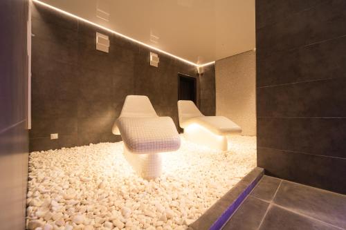 two white benches sitting on a carpet of rocks at Chaty - Resort AQUA MARIA in Veľaty