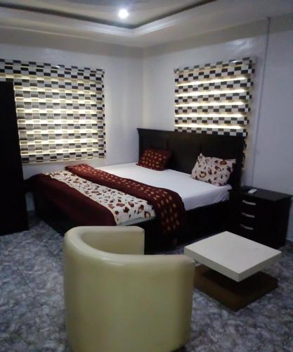 a bedroom with a bed and a couch and a chair at Kemi hotel in Ikeja