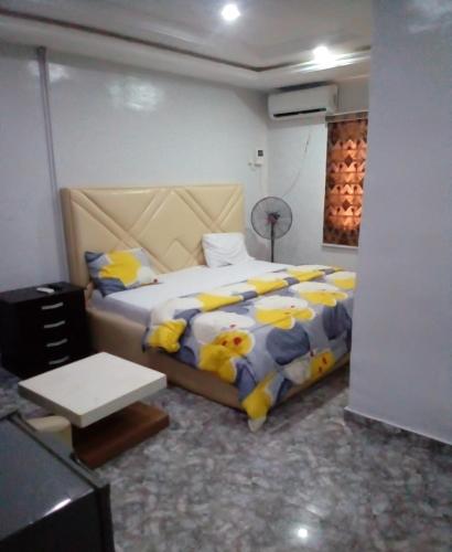 a bedroom with a bed with yellow and blue pillows at Kemi hotel in Ikeja
