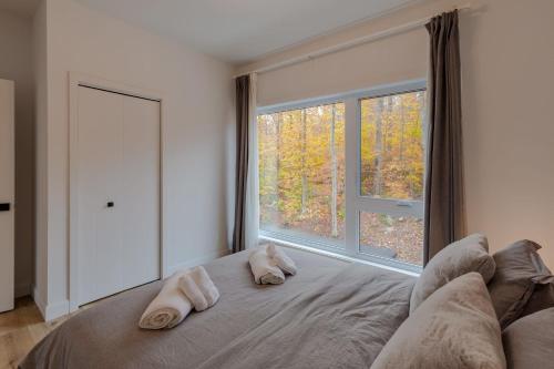 a bedroom with a large window with two towels on a bed at Mountain View Retreat with Private Hot Tub & Pool in La Conception
