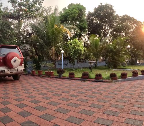 a red car parked in a parking lot at 7TH HEAVEN Kannur in Chakkarakkal