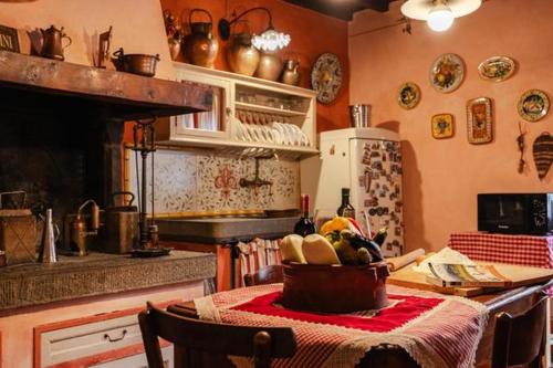 una cocina con una mesa con una cesta de comida. en LA FINESTRA SUL BORGO Dimora Storica, en Laterina