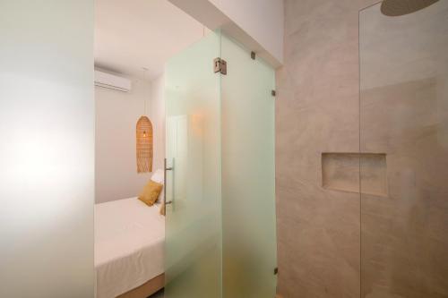 a bathroom with a glass shower and a bed in a room at Villa NOMA - Apartment w/ Lovely View I 5 min/Beach I Free SUP in Willemstad
