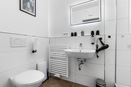 a white bathroom with a toilet and a sink at APARTVIEW Apartments Krefeld - WLAN - Zentral - ruhig in Krefeld