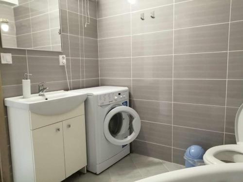 a bathroom with a washing machine and a sink at Oddychový pobyt na rodinnej farme in Matiaška